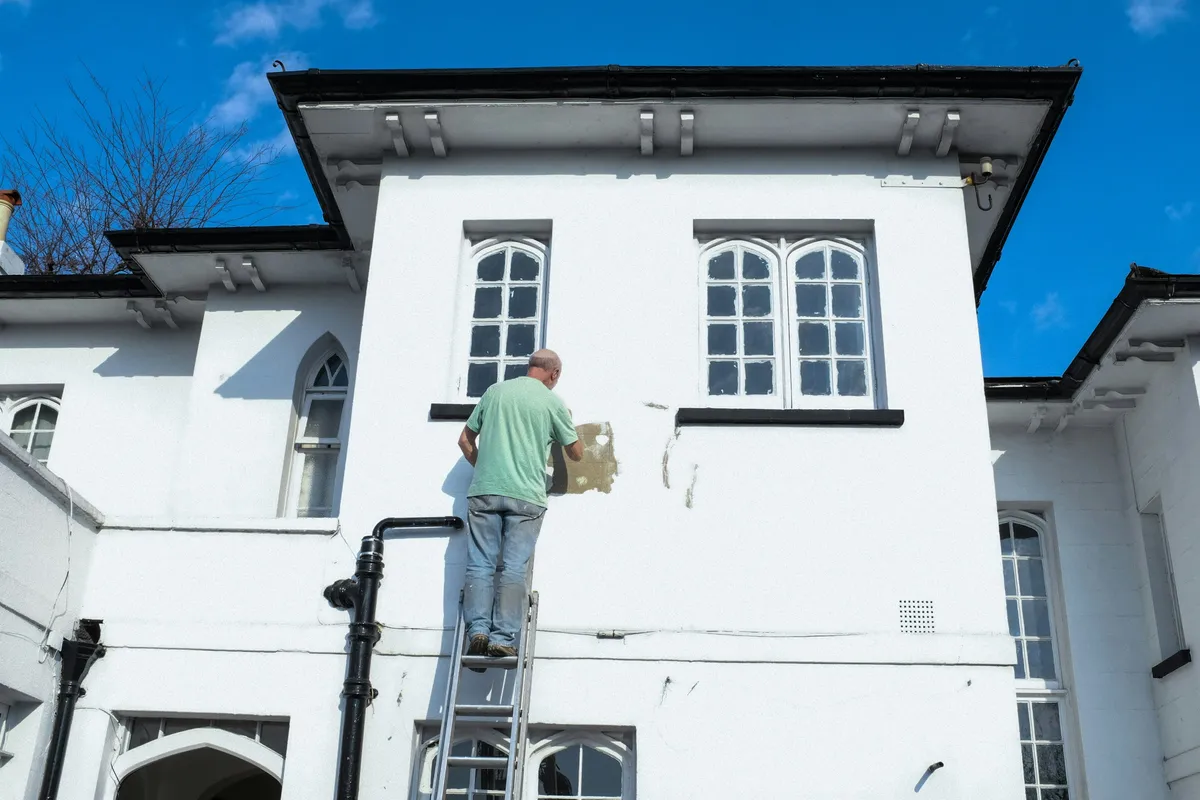 A painter rolling fresh paint onto an interior wall
